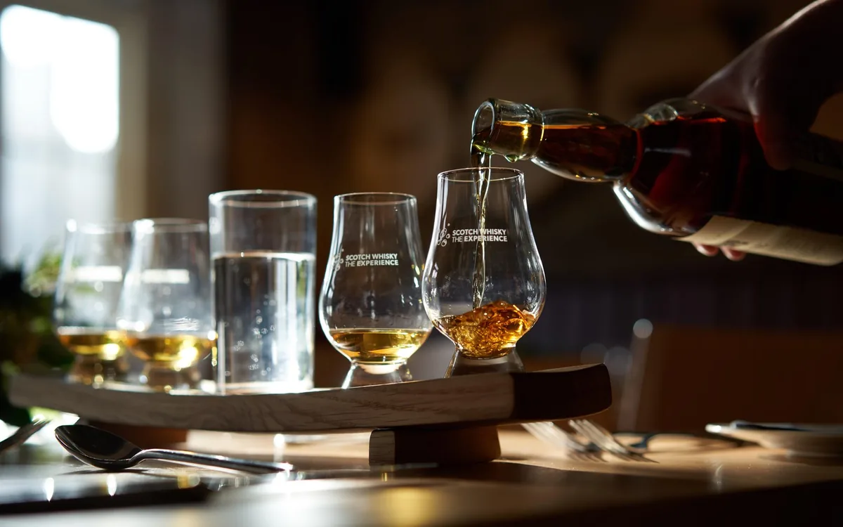 A dinner table in Edinburgh laid with whiskey glasses and three courses