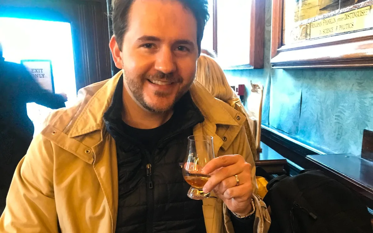 A whiskey expert talking a guest through a flight of glasses